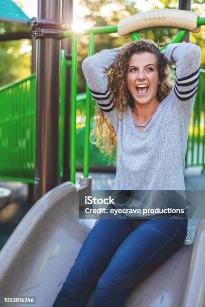 Young Adult Attractive Female College Student Early Autumn Fun In A Public Park Stock Photo - Download Image Now