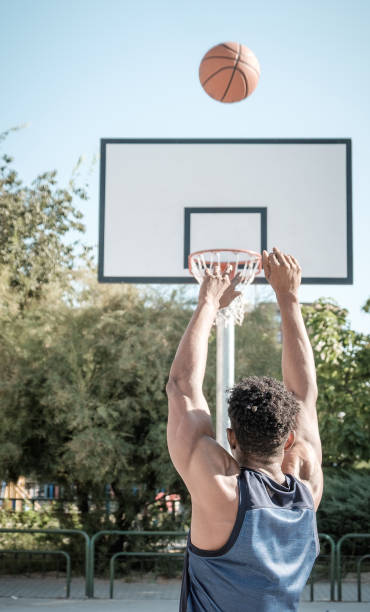 Afroamerican young man playing street basketball in the park stock photo