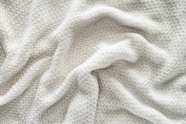 istock full frame of wavy white knitted cloth as background 1053816882