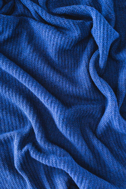 istock full frame of blue folded woolen fabric as background 1053816932