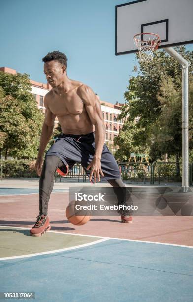 Afroamerican Young Man Playing Street Basketball In The Park Stock Photo - Download Image Now