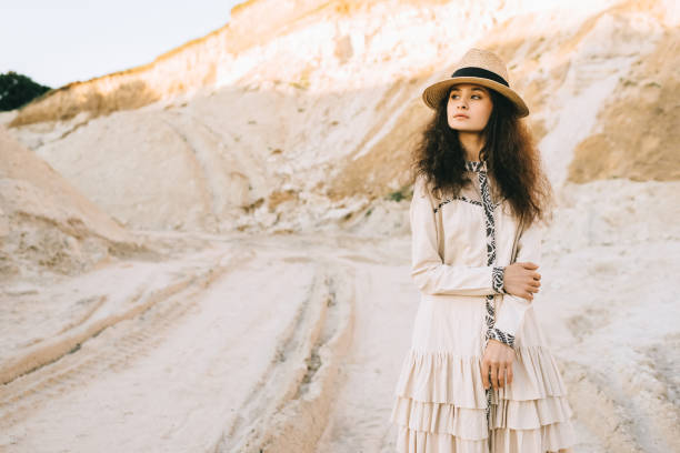istock attractive curly girl posing in straw hat in sandy canyon 1053818880