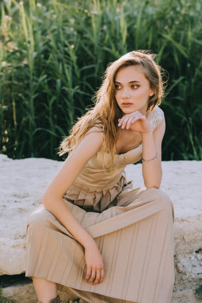 istock attractive elegant girl sitting on ground 1053820046
