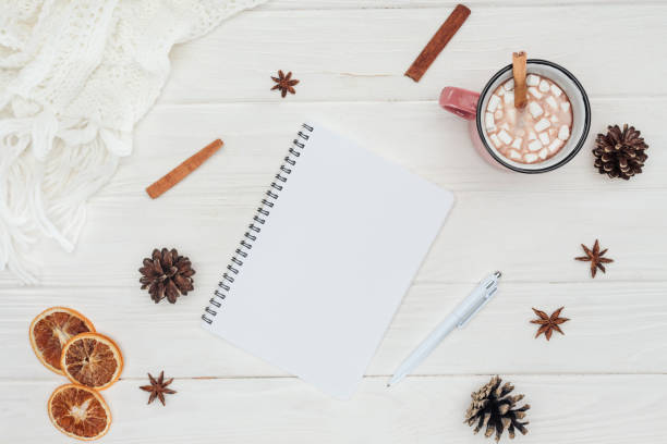 istock flat lay with blank notebook and cup of hot chocolate, marshmallows and cinnamon sticks on wooden table 1053820978