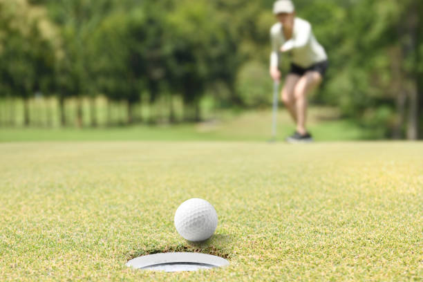 istock Woman golfer cheering after a golf ball on a golf green 1053821000