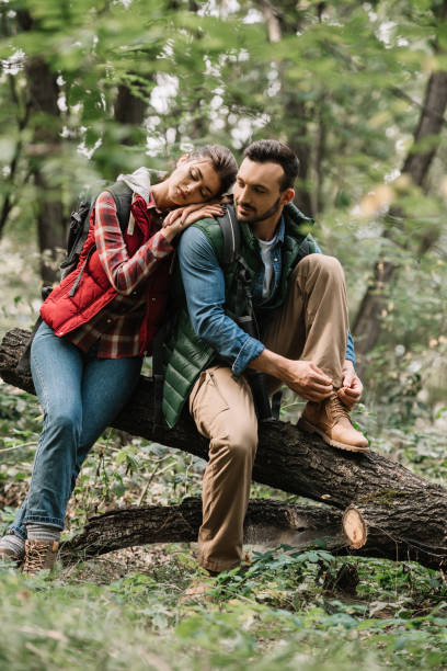 istock young travelers resting on log while hiking in forest 1053828458