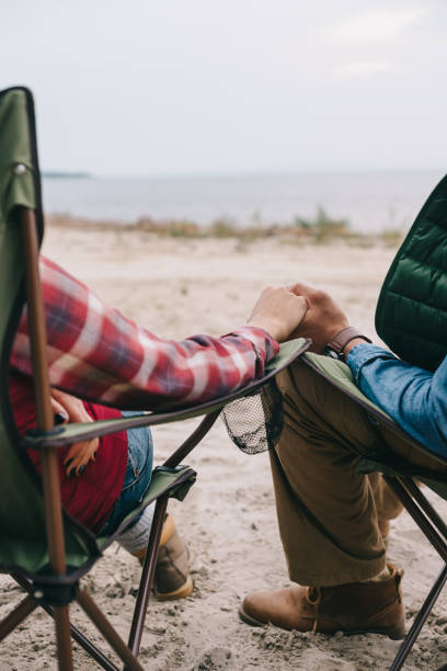istock partial view of man and woman holding hands while enjoying camping together 1053828628