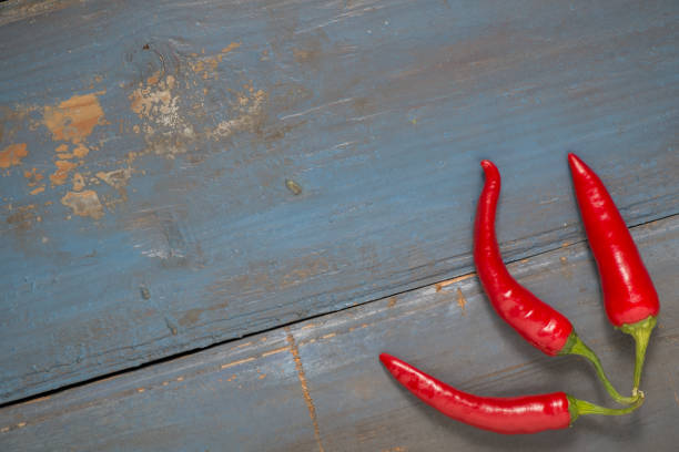 istock Red hot chilli peppers on a gray board table. Free space for text. Top view 1053829160