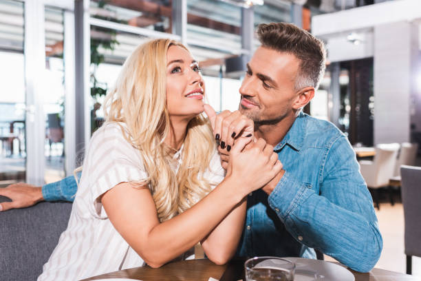 istock happy couple holding hands during date in cafe 1053834472