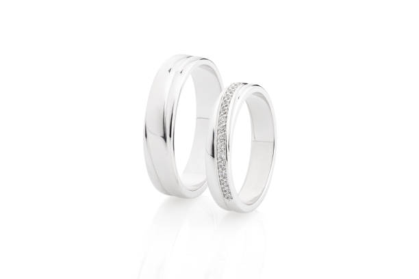 istock Pair of silver wedding rings with diamonds isolated on white background 1053835850