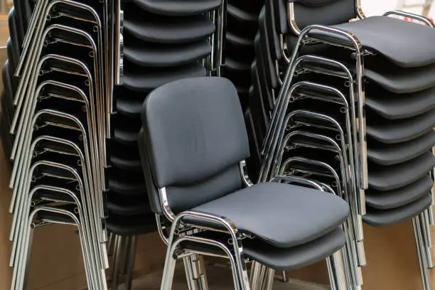 Photo of Leather and metal chairs stacked on top of each other in the meeting room.