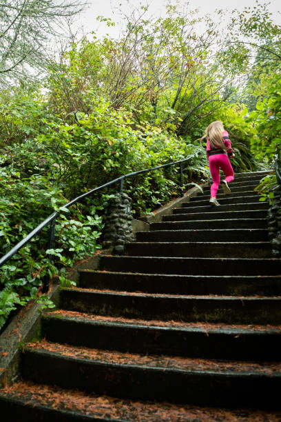 femme running up humide escalier entouré par wild, natif de feuillage - sweat women wet shirt photos et images de collection