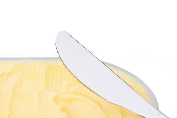 istock Cheese butter or margarine with knife isolated on white background 1053850216