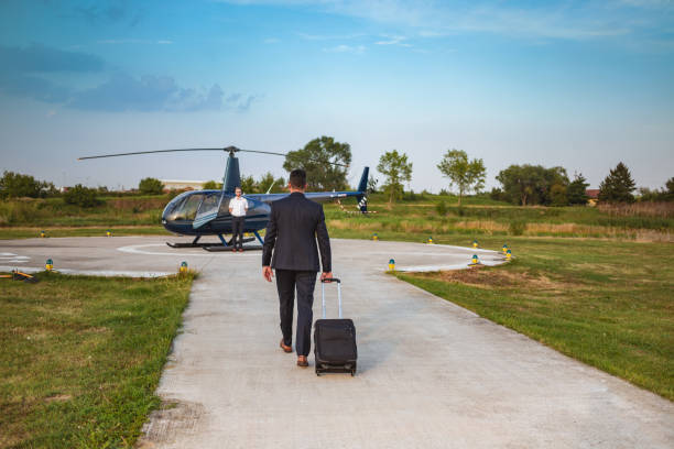istock Businessman walking to the helicopter, pulling suitcase 1053852588