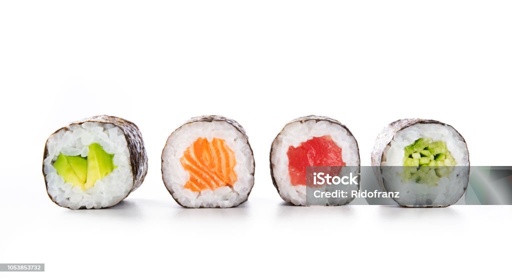 Maki sushi food Four maki rolls in a row with salmon, avocado, tuna and cucumber isolated on white background. Fresh hosomaki pieces with rice and nori. Closeup of delicious japanese food with sushi roll. Sushi Stock Photo