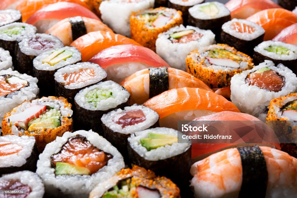 All you can eat sushi Overhead japanese sushi food. Maki ands rolls with tuna, salmon, shrimp, crab and avocado. Top view of assorted sushi, all you can eat menu. Rainbow sushi roll, uramaki, hosomaki and nigiri. Sushi Stock Photo