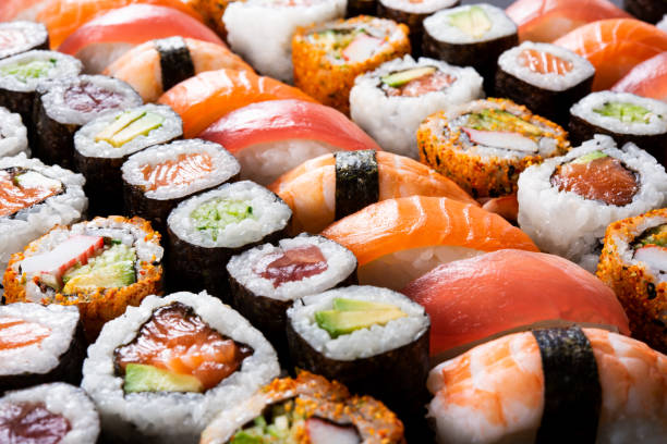 All you can eat sushi Overhead japanese sushi food. Maki ands rolls with tuna, salmon, shrimp, crab and avocado. Top view of assorted sushi, all you can eat menu. Rainbow sushi roll, uramaki, hosomaki and nigiri. japanese food stock pictures, royalty-free photos & images