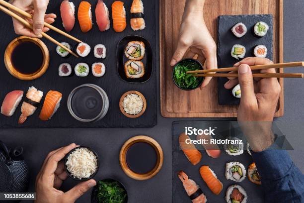 Sharing And Eating Sushi Food Stock Photo - Download Image Now - Sushi, Japanese Food, Restaurant