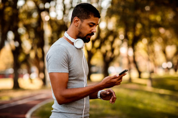 istock Male athlete using mobile phone on the running track 1053860214