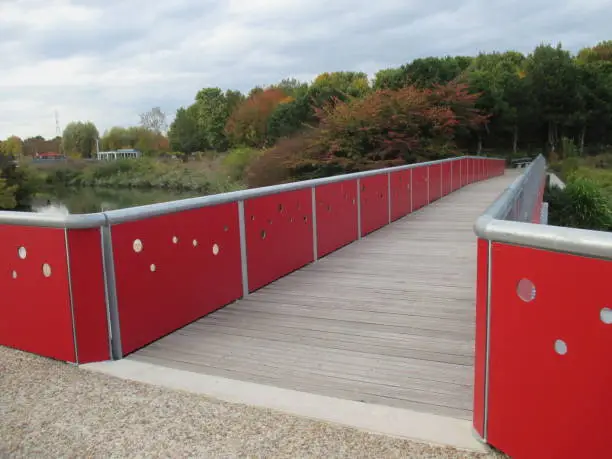 Bridge with guardrails spanning a pond in a public park  île-de-France