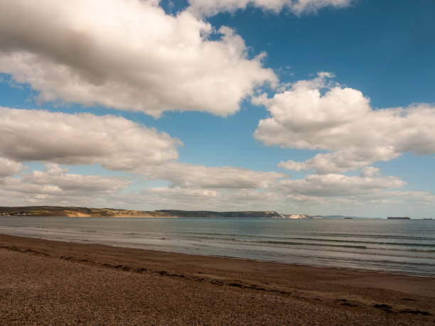 istock Weymouth beach dorset waves ocean water cliff tops white landscape open space beach 1053870400