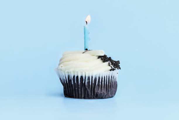 istock Chocolate Cupcake with Vanilla Buttercream Icing and Lit Candle 1053873686