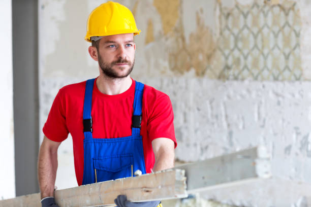 istock Young worker carrying wooden planks 1053890676
