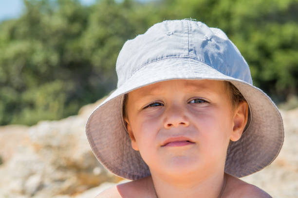Little boy in hat standing in nature