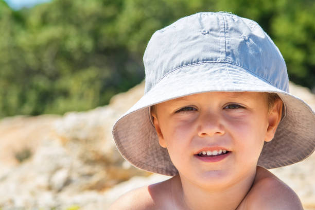 istock Little boy in hat standing in nature 1053891706