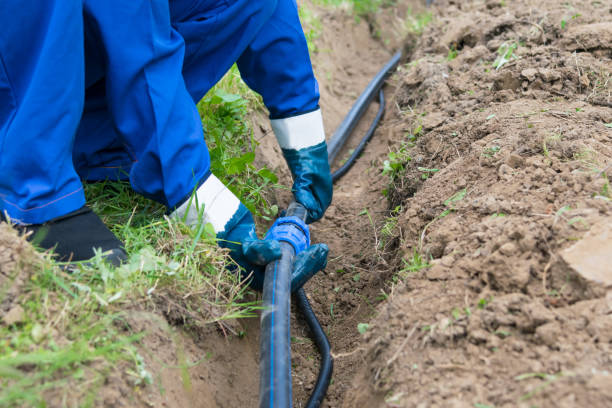 istock the master puts a black pipe into the ground, close-up 1053895266