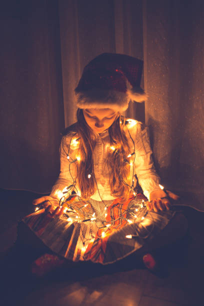 istock Girl holding colourful Christmas string lights 1053900420