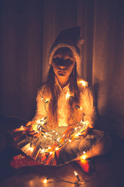 istock Girl holding colourful Christmas string lights 1053900578