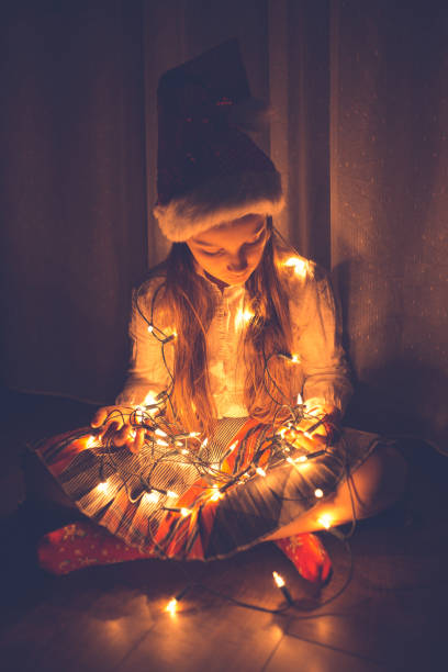 istock Girl holding colourful Christmas string lights 1053900586