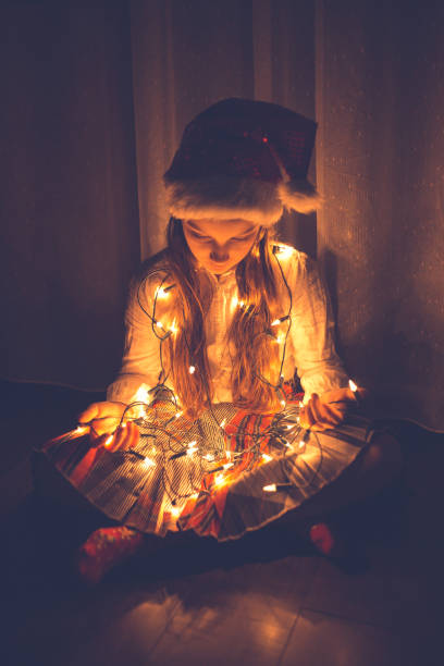 istock Girl holding colourful Christmas string lights 1053900854