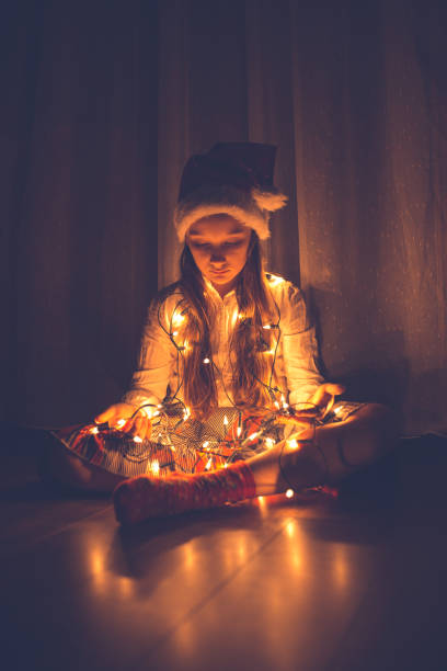 istock Girl holding Christmas string lights 1053901196