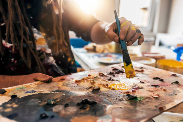 istock Painter mixes paint on the palette. Closeup 1053904658