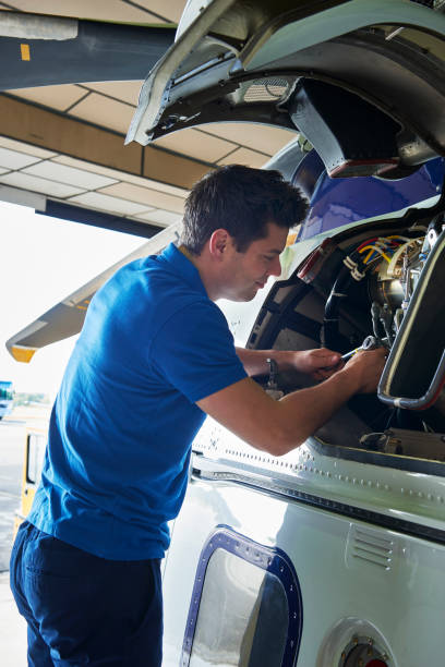 istock Male Aero Engineer Working On Helicopter In Hangar 1053905450