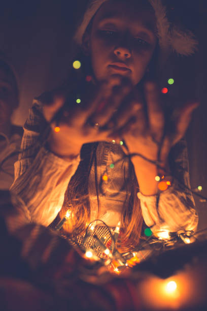 istock Young girl with christmas lights in her hand 1053907438