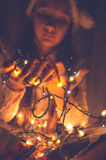istock Young girl with christmas lights in her hand 1053907604