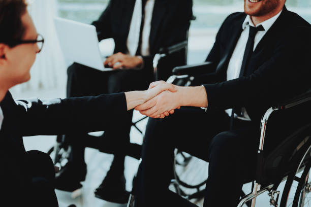 istock Two Disabled on Business Meeting Shaking Hands. 1053909324