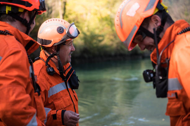 istock Firefighters in a rescue operation - talking by the river 1053914002