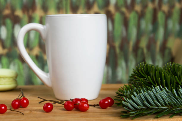 istock White Cup, red berries and spruce branches on wooden background color. 1053915256