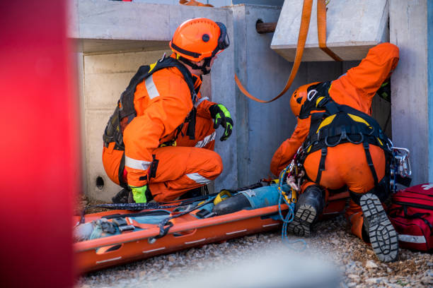 rescatar a una persona herida de las ruinas, los bomberos rescate operación - orange uniform fotografías e imágenes de stock