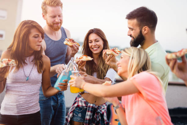 istock Group of happy friends having party on rooftop 1053918752