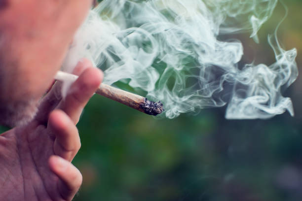 A man smokes a joint. Medical marijuana use and legalization of the cannabis, light drugs concept Man smokes a joint. Medical marijuana use and legalization of the cannabis, light drugs concept hashish stock pictures, royalty-free photos & images