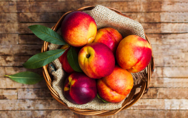 istock Peaches on a rustic wooden background 1053922522