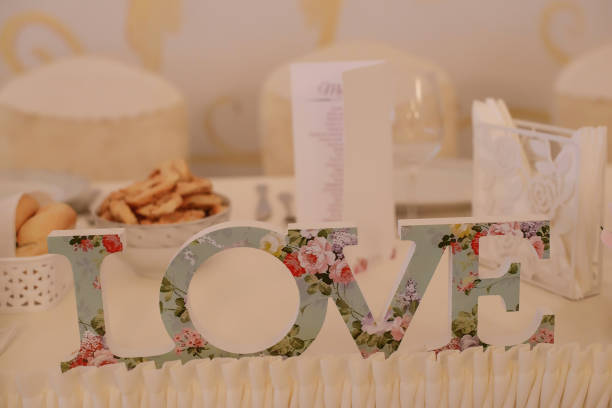 stand seul lettres plaque avec embellissement floral vintage, qui se lit d’amour - floral centerpiece photos et images de collection