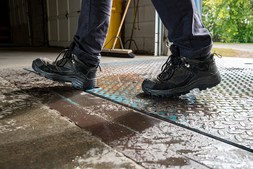 Warehouse worker walking on a wet tread plate on a loading dock