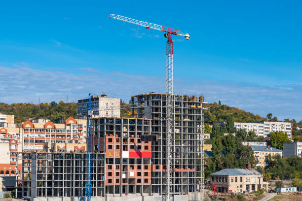 istock Construction crane and a tall building under construction in the background of the mountain 1053932560