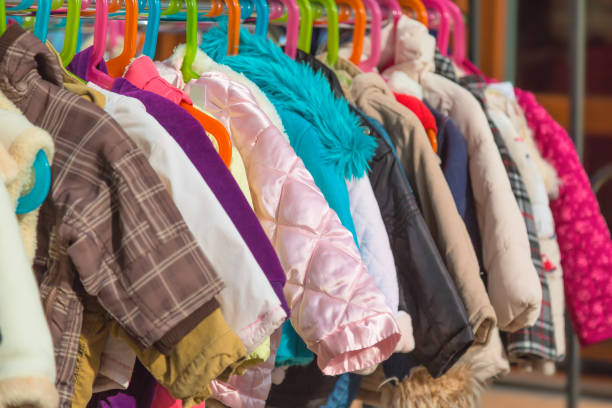 rack of baby and children used dress, clothes displayed at outdoor hanger market for sale. - coat imagens e fotografias de stock